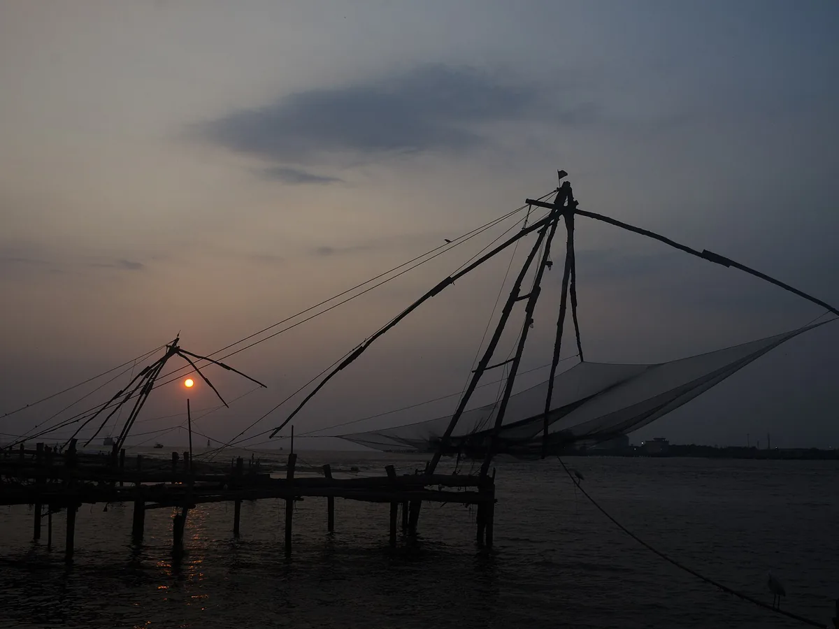 Chinese fishing nets silhouetted at sunset on the Fort Kochi waterfront